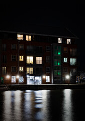 Illuminated Quayside Apartment Block Across The Quay At The Historic Docks At Gloucester At Night In Winter