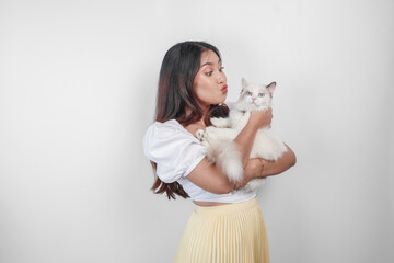 Portrait of young Asian woman holding cute ragdoll cat with blue eyes. Female hugging her cute long hair kitty isolated by white background. Adorable domestic pet concept.