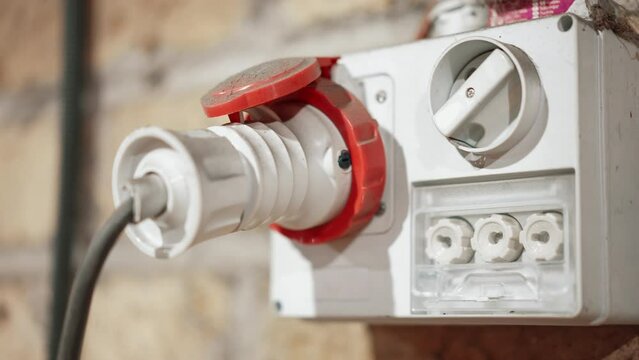 White power outlet on external wall with plug in, high voltage three-phase electrical power supply used in hardware industries, power supply and electricity concept