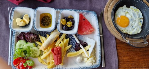 hotel breakfast in turkey eggs, fries, olives sausage cheese vegetable