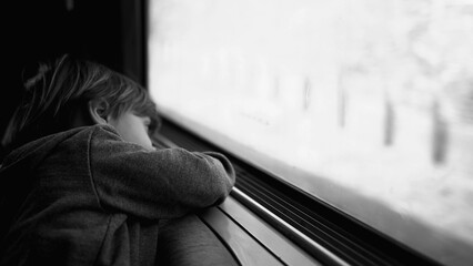 Melancholic Child on Train - Reflective Moment in Black and White of sad depressed little boy...