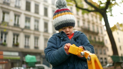Small Boy at Play in Autumn Park - Child Engrossed with Toy Truck in Chilly Weather