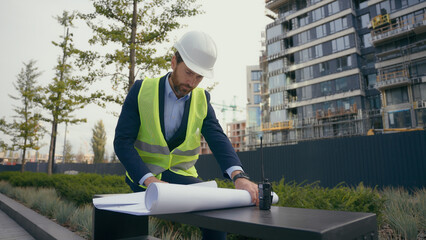 Pensive male architect thoughtful looking around think check urban infrastructure manufacture blueprint thinking worker repairman man in city solving building decision look at build plan architecture