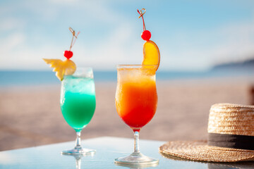 Tropical cocktails on beach table with sea view. Summer vacation and travel.