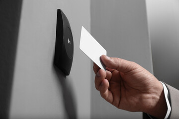 Man opening magnetic door lock with key card, closeup. Home security