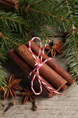 Different spices and fir branches on wooden table, flat lay