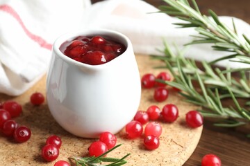 Cranberry sauce, fresh berries and rosemary on table, closeup