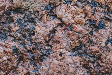 Surface of red big grained rough granite rock as an abstract background.