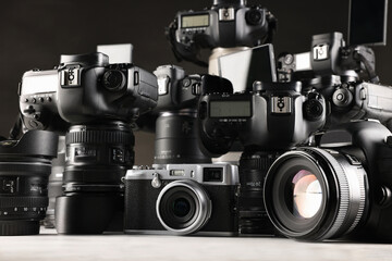 Modern cameras on white wooden table, closeup