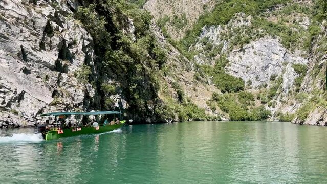 Boat with tourists on Shala river, Komani lake, reservoir in the Albanian Alps.