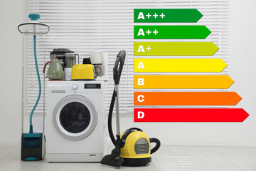 Energy efficiency rating label and different household appliances near window indoors