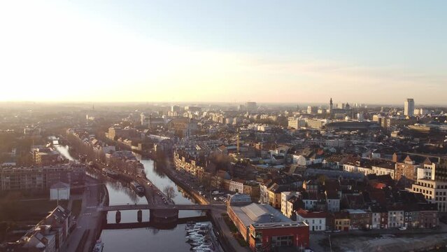 Aerial view of the city of Ghent at sunrise. Orange-yellow light on the water canals and the center of Gante. Dawn over the city of Flanders, Belgium