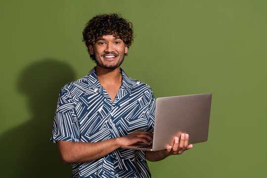 Photo of good mood funky guy wear print shirt chatting twitter telegram facebook empty space isolated khaki color background