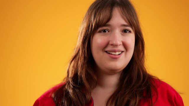Portrait of pretty thinking young woman 20s, looks at camera gives mind blown gesture showing explosion of ideas posing on yellow background with copy space.