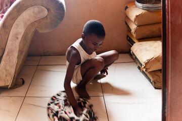 village african small girl washing the floor inside the house