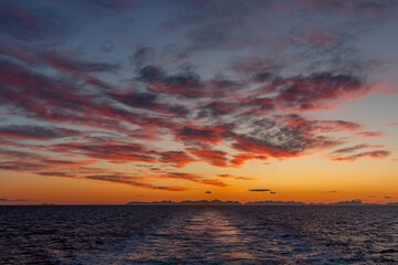 Sunset with red sky from the ferry with the islands in the background