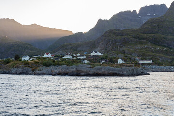 Set of white wooden houses with the evening sun rising over the mountains
