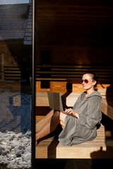 Fototapeta na wymiar Frau sitzt mit Laptop in der Sauna