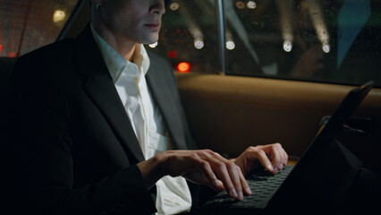 Focused director working computer in vehicle closeup. Business man typing tablet