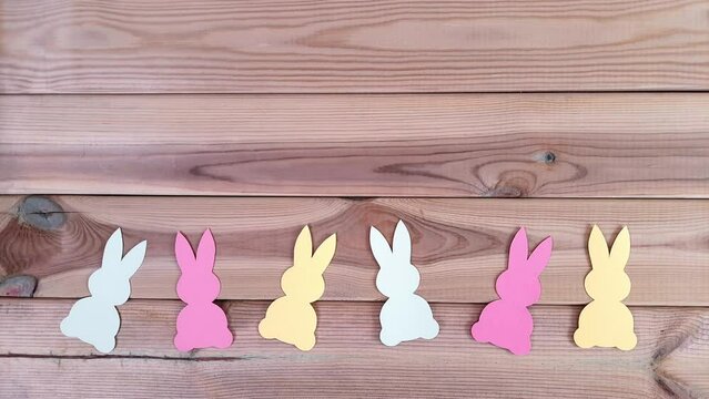 Dance of cute bunnies. Multi-colored dancing rabbits cut out of paper. Template for Easter greeting, art class, children's art studio, school, preschool.