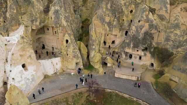 View of the Goreme Open Air Museum in Cappadocia, Turkey. This Unesco World Heritage site is an essential stop on any Cappadocian itinerary. Tourists visiting the historical site.