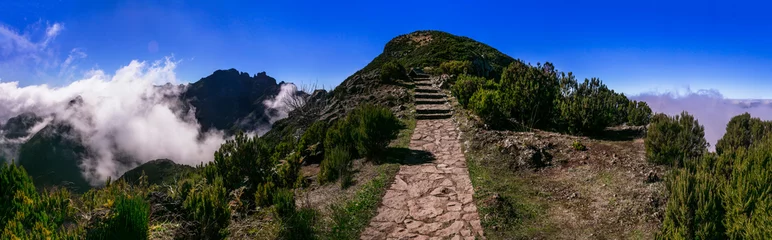 Gordijnen Hiking activity in Madeira island rocky mountains. Trail for Pico Ruivo highest point passing in the clouds © Freesurf