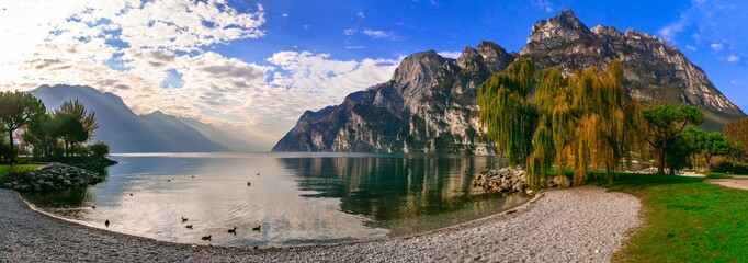Italy travel ,scenic Garda lake , Trento province.  Lago di Garda. Wonderful autumn scenery. sunny morning in Riva del Garda. - obrazy, fototapety, plakaty