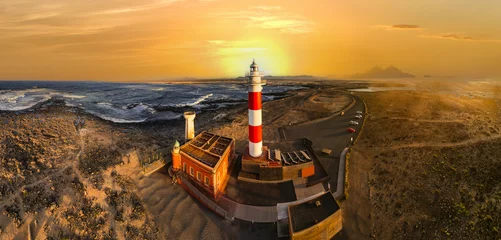 Gordijnen scenic  landscape with lighthouse over sunset. aerial drone view, Fuerteventura . Canary island, El Cotilio village. El Toston lighthouse. © Freesurf