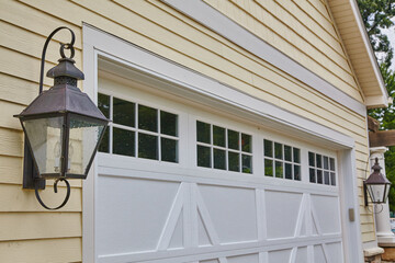 Vintage Lantern and White Garage on Yellow House Facade