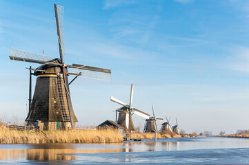 View at the famous Kinderdijk windmills in The Netherlands. The Kinderdijk windmills are a group of 19 monumental windmills in the Alblasserwaard polder, in the province of South Holland, Netherlands.