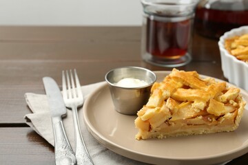 Piece of tasty homemade quince pie with ice cream on wooden table, closeup. Space for text