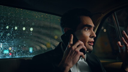 Emotional businessman arguing phone in vehicle closeup. Boss shouting cellphone