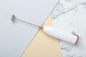 White milk frother wand on color background, top view