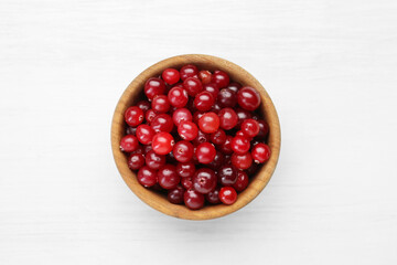 Fresh ripe cranberries in bowl on white table, top view