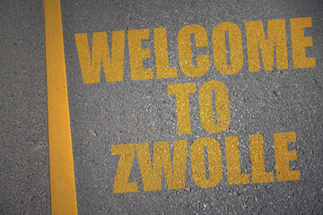 asphalt road with text welcome to Zwolle near yellow line.