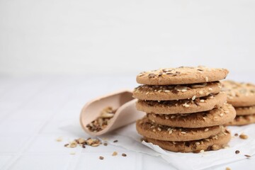 Cereal crackers with flax and sesame seeds on white tiled table, closeup. Space for text