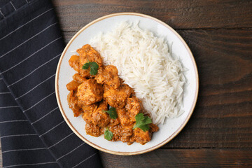 Delicious chicken curry with rice on wooden table, top view