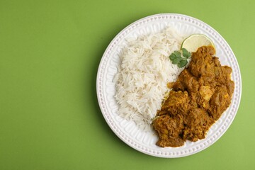 Delicious chicken curry with rice on green background, top view. Space for text