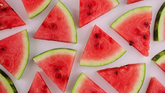 Red fresh watermelon sliced into triangles rotate in sunlight on isolated white background for your top view design. Healthy fruit berries. Summer fresh fruit snack. 