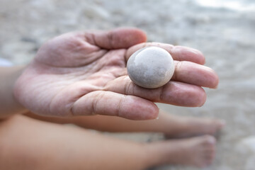 Woman holding pebbles in hand at beach