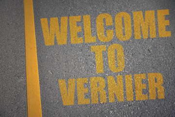 asphalt road with text welcome to Vernier near yellow line.