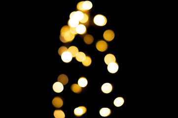 Golden blurred bokeh lights on black background. Christmas lights overlay.