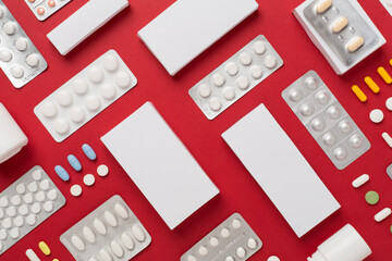 Different pills in blister packaging and boxes and on color background, top view