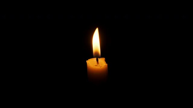 One candle burning and extinguished on a black background, copy space. Candle flames lit close-up. Fire flames of candlelight. Isolated. Concept remembrance, celebration, religion, memories, etc. 4K
