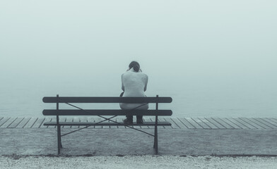 Depressive Frau auf Bank sitzend
 - obrazy, fototapety, plakaty