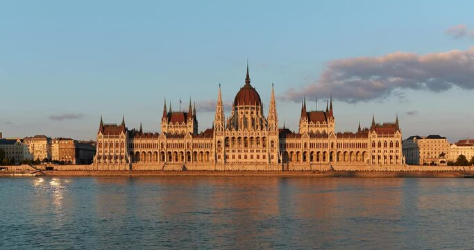 Timelapse Residence of Hungarian Parliament, Budapest night city lights illuminated backdrop of sunset evening on sunny day in summer. National building symbol view from other bank of Danube Rive