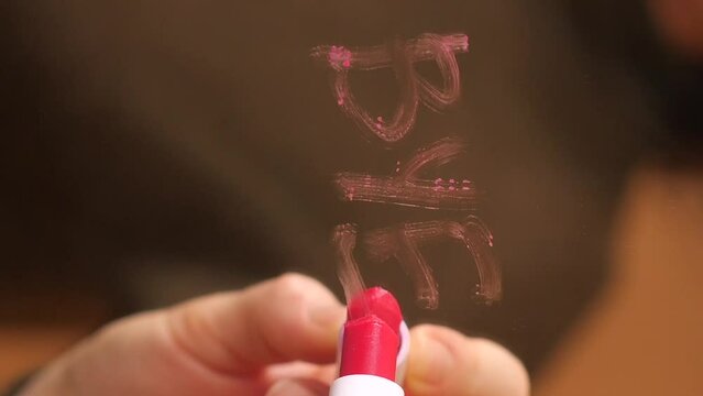 girl writes the word bye with red lipstick. relationship breakup concept