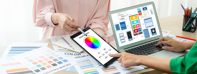 Cropped image of interior designer team presents color by using color palette while laptop...