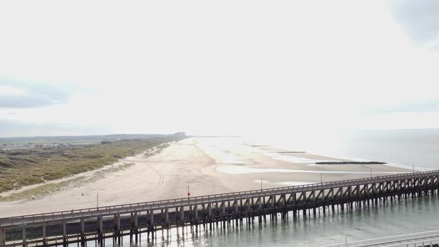 Aerial view of the white wooden pier in the town of Blankenberge on the Atlantic coast of Belgium during the morning sun