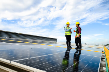 Two energy engineers are discussing and inspecting solar panel installation on the roof for performance standards. Controlling Cutting-Edge Technology for Clean.